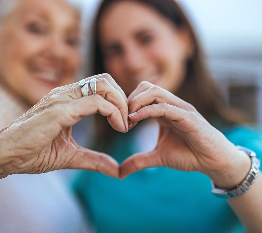 two women making heart shape with hands